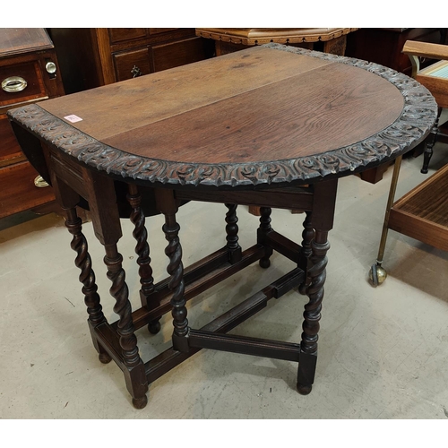 882 - A carved oak dining table with drop leaf top