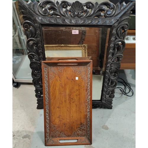 906 - A large oak carved cushion framed, bevelled edge mirror with scrolling pierced frame and with shell ... 