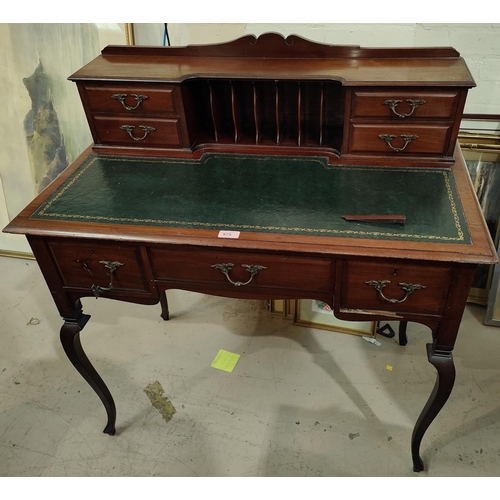 975 - A mahogany desk with letter rack, drawers behind, and three below, length 91cm; an oak armchair