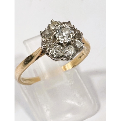 615 - An 18 carat hallmarked gold ring set central diamond, 5mm approx., surrounded by 8 smaller stones, 3... 