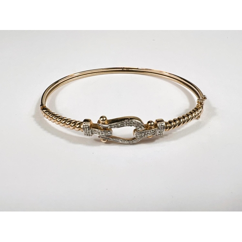 627A - A 9ct hallmarked gold hinged bangle with horseshoe shaped mount set with small diamonds 5.7gm 