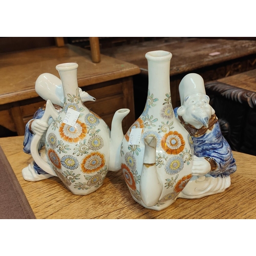 427C - A pair of unusual Chinese tea pots in the form of men sat with vases with spouts, (one bearing damag... 