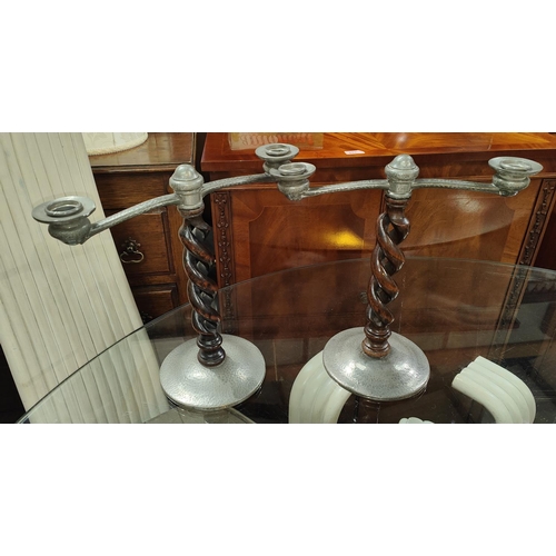 57A - A pair of Tudric planished pewter 2 branch candelabra on open barley twist columns.