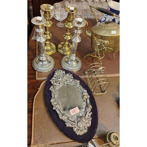 637 - A white metal framed mirror on purple backing, a pair of silver plated candlesticks, two brass and a... 