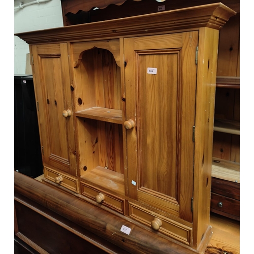 984 - A pine wall hanging kitchen cabinet with central open shelves, two cupboards and three drawers