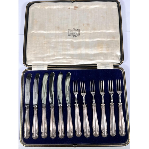 604 - A cased set of 6 silver handled knives and forks, filled centres, Harrods case