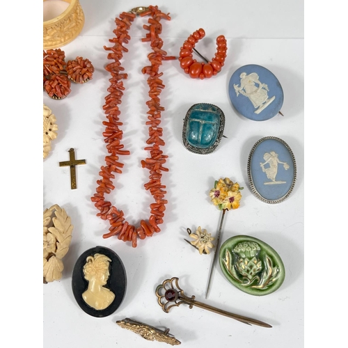 737 - A selection of vintage costume jewellery:- Cameo brooches and pendant; carved bone brooches, a coral... 