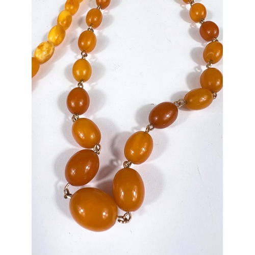 742 - Two amber coloured necklaces with graduating beads; a clear amber coloured glass bead necklace and a... 