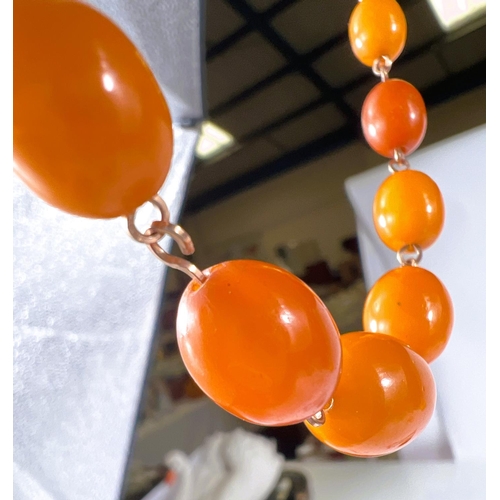 742 - Two amber coloured necklaces with graduating beads; a clear amber coloured glass bead necklace and a... 