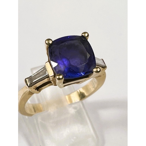 664 - A modern ladies dress ring set square cut tanzanite with diamond baton to each shoulder, the yellow ... 