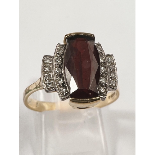 665 - An Art Deco style dress ring set garnet surrounded by 18 small diamonds, 18 carat yellow gold shank,... 