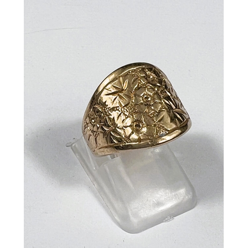 709 - A 9 carat hallmarked gold ring chased with flowerheads, size H/I, 7gm