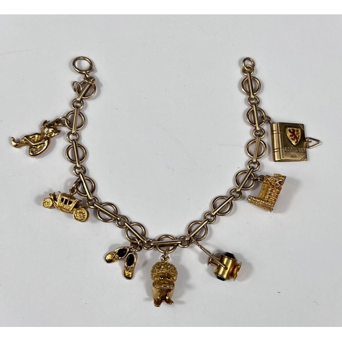 710 - A 9 carat hallmarked gold charm bracelet set 7 x 9 carat charms, 31gm