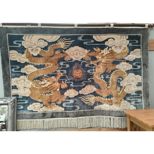 841 - A 20th Chinese wall hanging depicting two yellow five clawed dragons on blue back ground, fringe to ... 