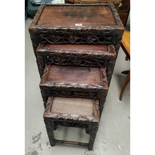 986 - A 19th century Chinese carved wood nest of four occasional tables with scrolling leaves and vines, g... 