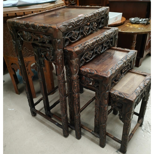 986 - A 19th century Chinese carved wood nest of four occasional tables with scrolling leaves and vines, g... 