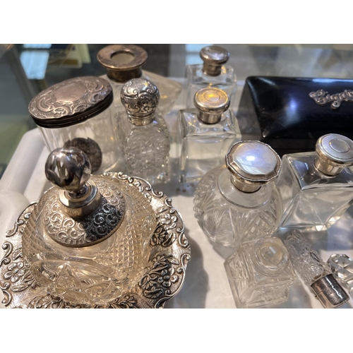 764A - A selection of silver topped scent bottles, an ebonised cigarette box with silver applied, other whi... 