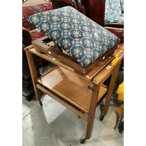 879 - An oak 2 tier trolley/table; an adjustable gout stool with needlework upholstery