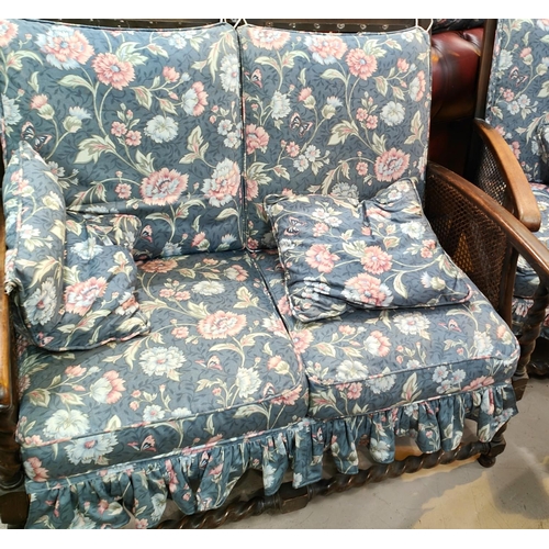 904 - An early 20th century oak barley twist and bergère two seater settee with matching armchairs,... 