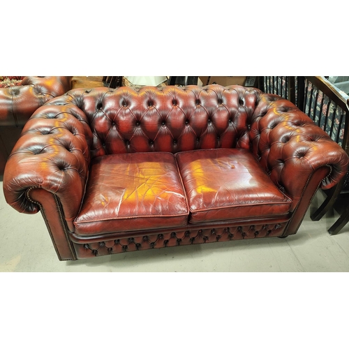 996 - A traditional red leather deeply buttoned back two seater settee with scrolling back, length 148cm (... 