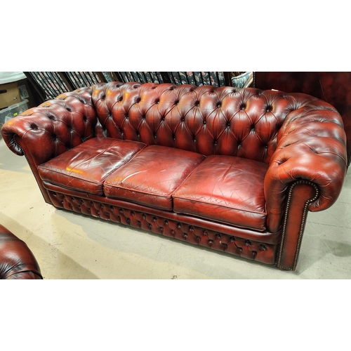 997 - A traditional red leather deeply buttoned back three seater settee with scrolling back, length 190cm... 