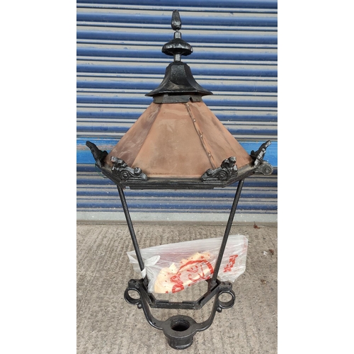 126 - A large Victorian style street lantern top of cast metal and copper, glass missing