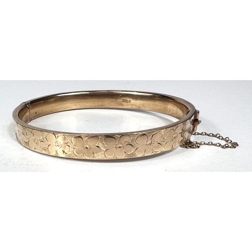 574 - A 9 carat hallmarked gold bangle with chased decoration, 11gm