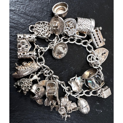 578 - A hallmarked silver charm bracelet with 17 charms, 3oz