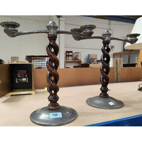 130 - A pair of Tudric planished pewter 2 branch candelabra on open barley twist columns.