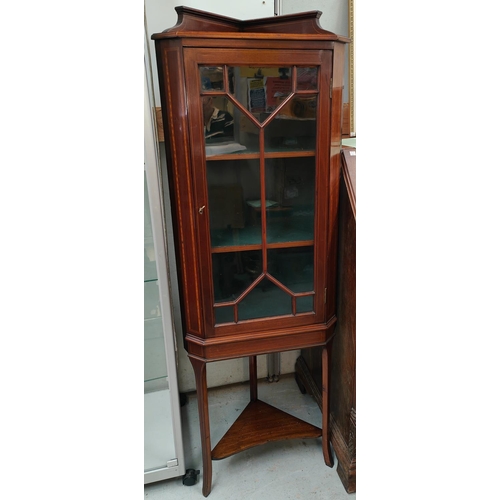 747A - An Edwardian inlaid mahogany display cabinet with single door and undertier