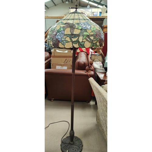 891 - An Art Nouveau style bronzed metal standard lamp with a Tiffany style shade.