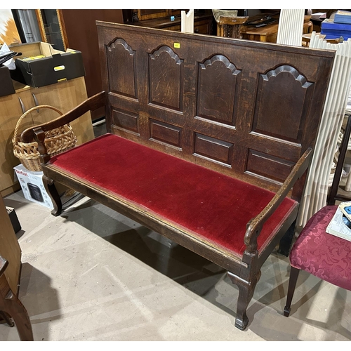 850 - An 18th century oak hall settle with arched fielded panels to the back, wine coloured seat and squar... 