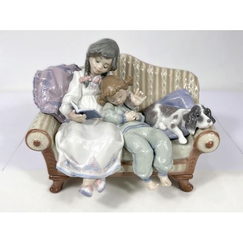 573 - A Nao group:  girl on sofa reading to younger girl, with dog, No 5735