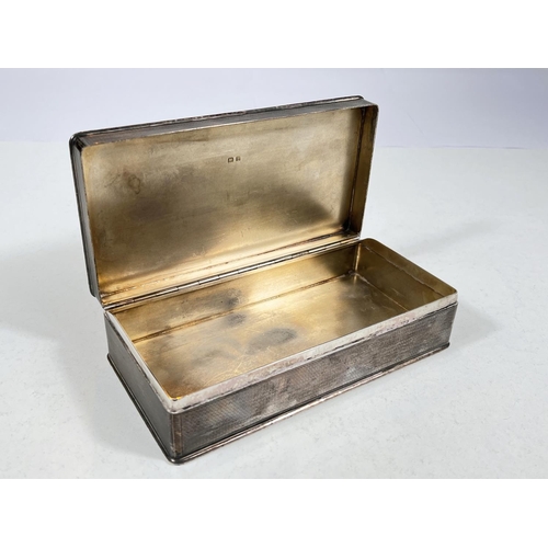 610 - A hallmarked silver rectangular cigarette box with engine turning, Birmingham 1926