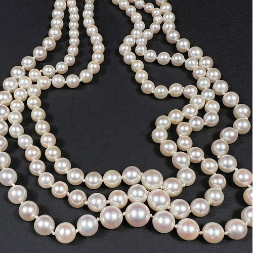 613 - A triple strand pearl necklace, the white metal clasp set multiple diamonds