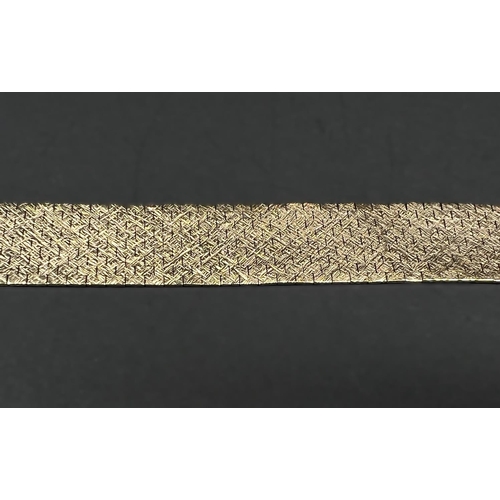 615 - A 9 carat wide reticulated bracelet in bark effect, 51.8gm