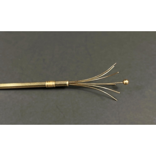 616 - A 9 carat hallmarked gold cocktail stick, retractable with swivel stick, engine turned, 6gm