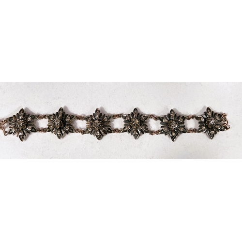 655 - A Victorian silver and gold bracelet in the form of silver flowerheads set with central raised diamo... 