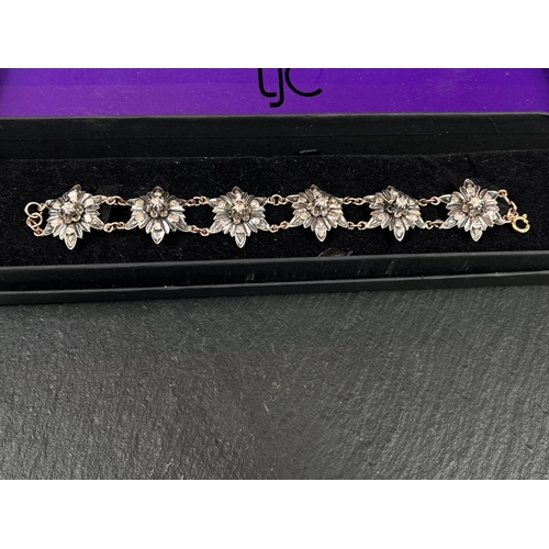 655 - A Victorian silver and gold bracelet in the form of silver flowerheads set with central raised diamo... 