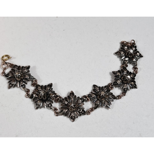 655 - A Victorian silver and gold bracelet in the form of silver flowerheads set with central raised diamo... 