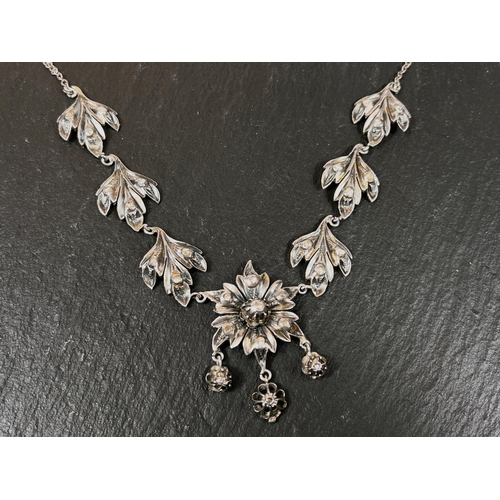 655A - A Victorian silver and gold necklace with 3 leaf shapes set with diamonds to either side of central ... 