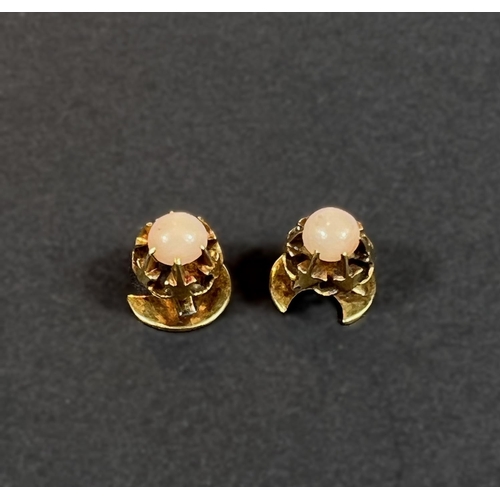 704 - A pair of 18ct gold studs each set with pink cabochon, 2.15gm