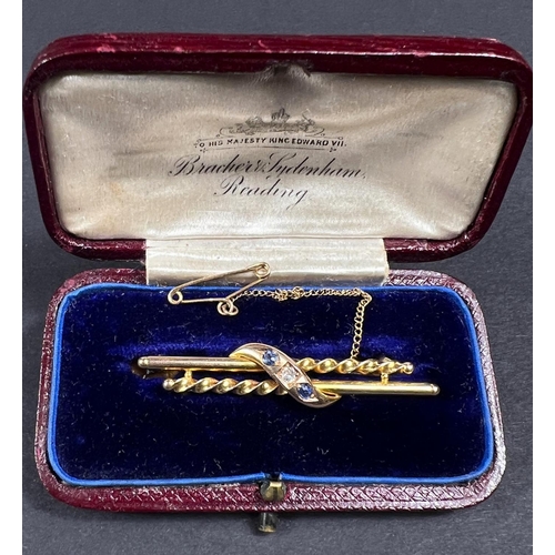 741 - A 15ct gold brooch with alternating straight and twisted bar with central set diamond with sapphire ... 