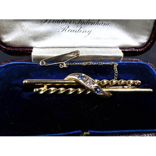 741 - A 15ct gold brooch with alternating straight and twisted bar with central set diamond with sapphire ... 