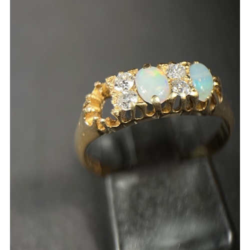 744 - An 18ct gold dress ring set with four diamonds and two opals (gap for a 3rd missing) 3.7gm M/N