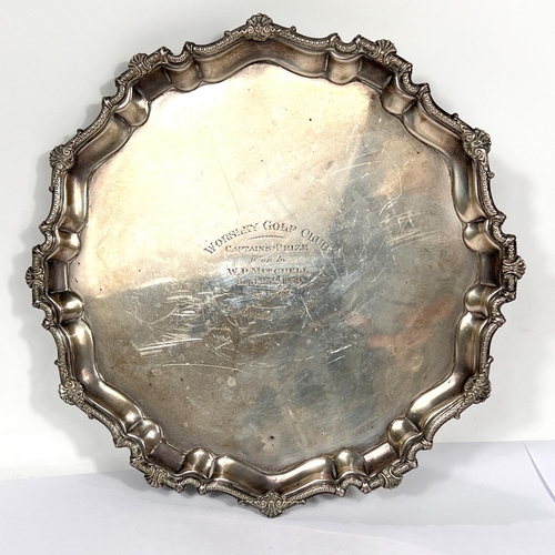 604 - A hallmarked silver salver with scalloped shell border and scroll feet, inscribed, Birmingham 1935, ... 