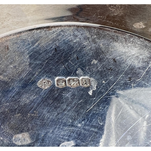 607 - A hallmarked silver circular bottle stand with wide pierced border, Sheffield 1918, diameter 24cm, 1... 