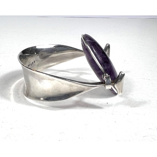 650 - Georg Jensen:designed by Vivianna Torun Bulow-Hube, a silver bangle with central oval polished ameth... 