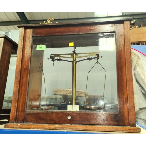 265 - A mahogany cased laboratory balance with weights in a mahogany and glass cabinet