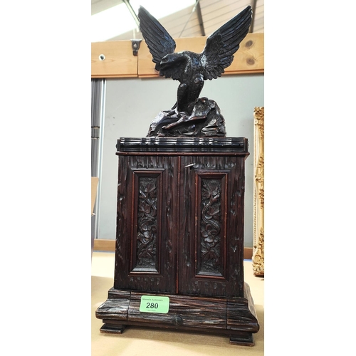 280 - A 19th Black Forest carved cigar humidor in the form of eagle standing atop cupboard with double doo... 